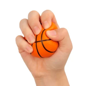 Balle anti stress en forme de ballon de basketball, pressée dans une main pour exercice de relaxation