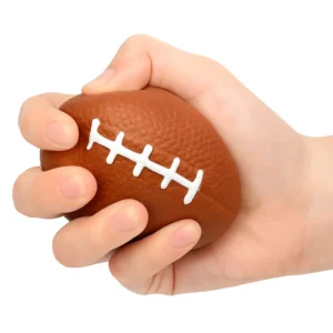 Balle anti stress en forme de ballon de rugby, pressée dans une main pour soulagement de la tension
