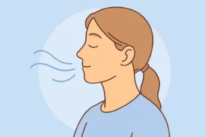 Profil d’une femme illustrant le souffle lent et contrôlé d’un exercice de respiration consciente